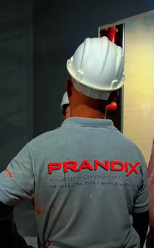 Profissional da construção civil utilizando EPI completo em obra comercial da Prandix, destacando a cultura de segurança do trabalho da empresa.